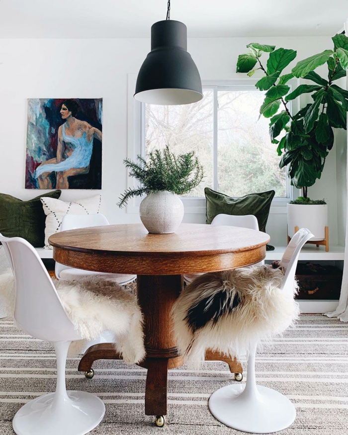 runder tisch aus holz weiße stühle modern artistisches gemälde an die wand große grüne deko pflanze hyggelig wohnen ideen