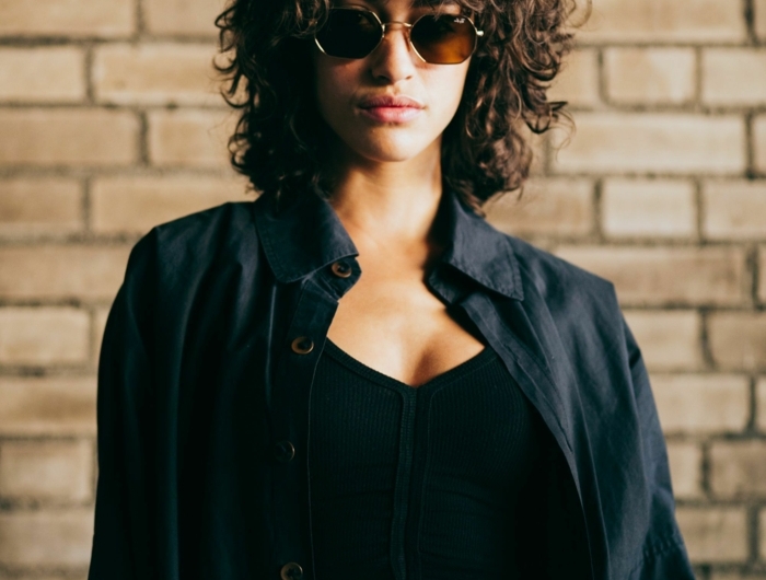 schwarzes crop top und hemd monochromes outfit inspiration kurze haare frisuren locken braun runde sonnenbrillen