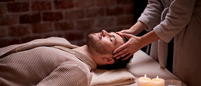 man getting face massage in spa beauty salon