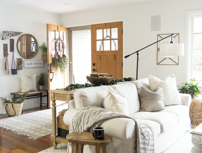 wohnzimmer skandinavischer stil bode und tür aus holz weißes sofa mit vielen kissen hygge style einrichtung