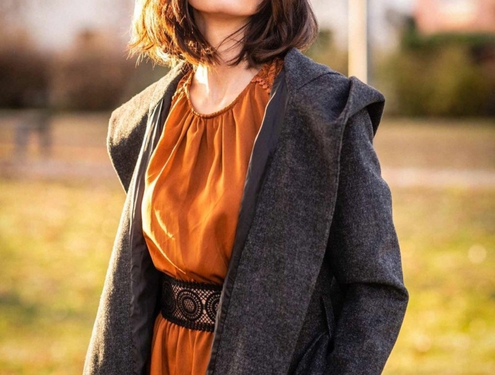 fashion shoot im park herbst outfit grauer mantel ocker kleid dame mit braunen haaren kurzhaarschnitte choppy bob 2021