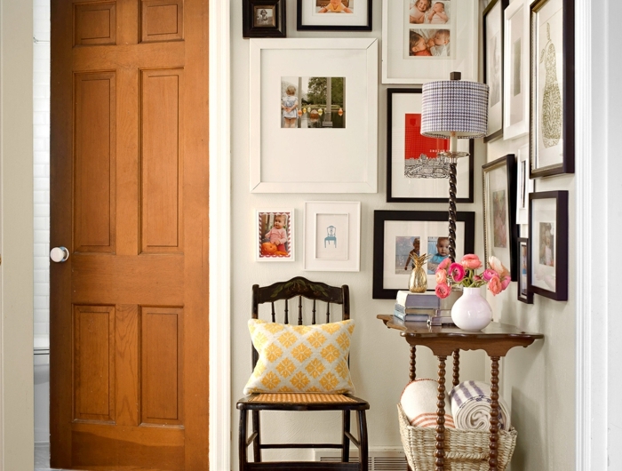 flur gestalten wände mit vielen bildern und fotos vintage stuhl aus holz kleiner tisch blau weiße vase dekoration inspiration eingangsbereich