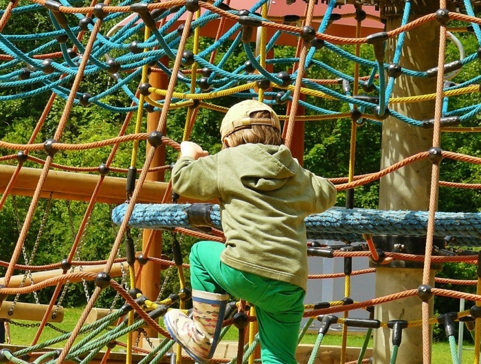 indoor klettergerüst vorteie kind spielt auf einem spielplatz mit klettergerüst