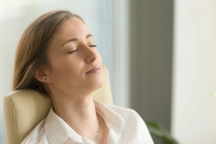 businesswoman lying on back chair with closed eyes