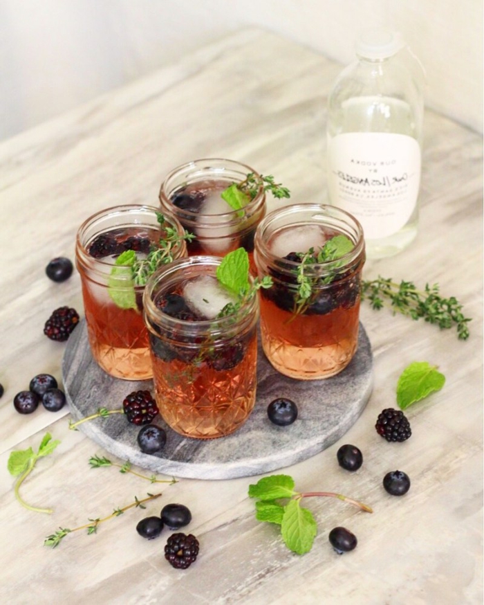 tablett mit vier gläsern mit getränken cocktail rezepte mit beeren und wodka erfrischende sommer getränke
