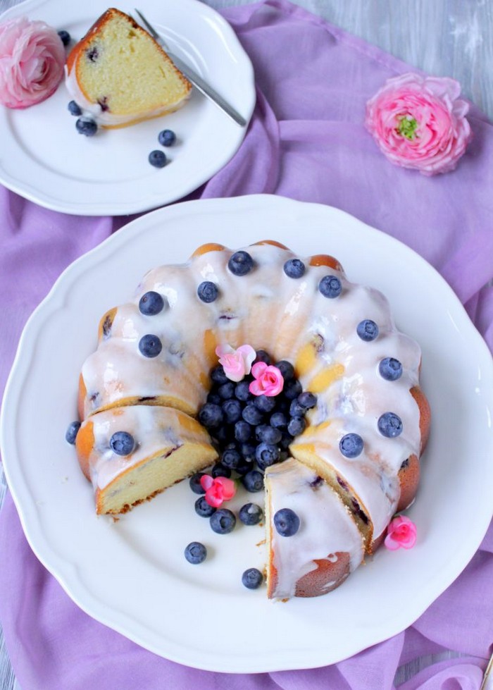 zitronenkuchen rezept saftiger zitronenkuchen mit blaubeeren kuchen chefkoch fluffiger saftiger zitronenkuchen zitronenkuchen saftig blaubeeren auf weiße teller