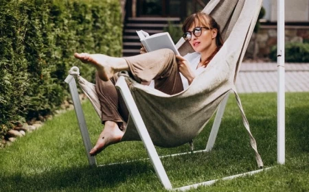 woman reading a book in the garden by the house