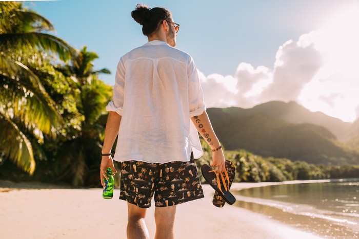 lustige badebekleidung wie badeanzug auswählen sommer man in badehosen weißes hemd bierflasche am strand