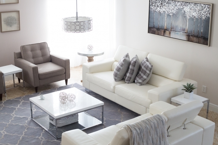 raumakustik optimieren schallabsorber deckenplatten aufhängen polstermöbel weiße sofa kaffeetisch
