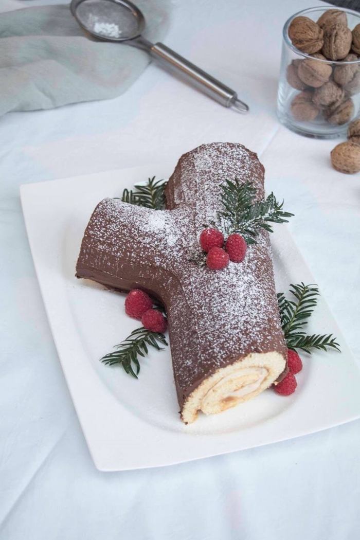 schokoladen la buche de noel bestreut mit puderzucker dekoriert mit weihnachtsdeko