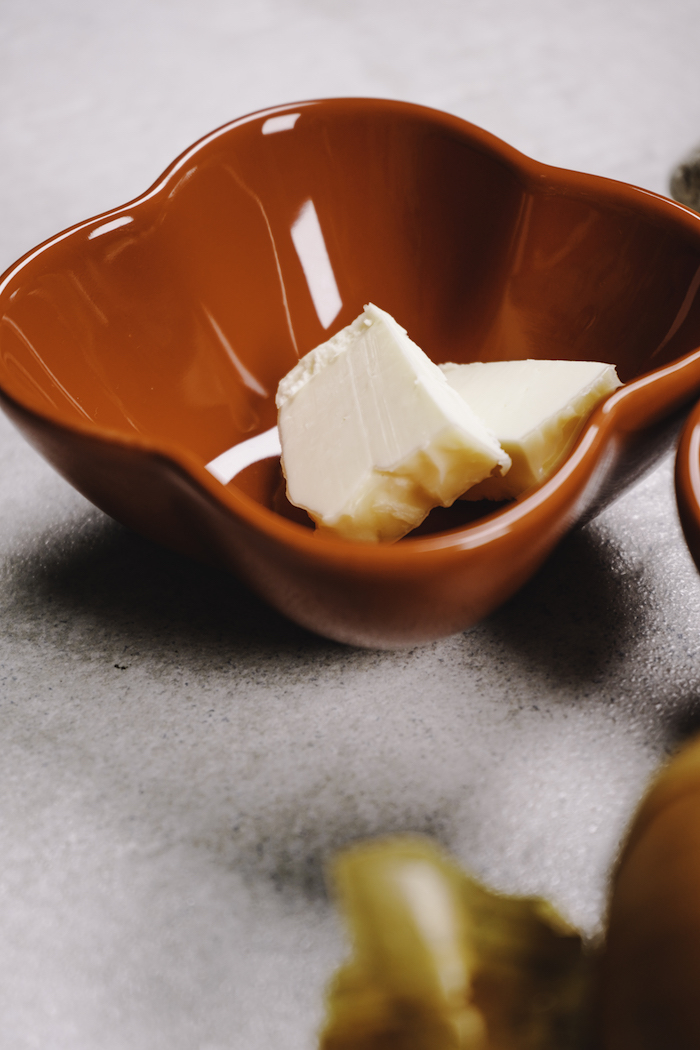 6 kleine stücke butter in einer roten schale zutaten für spinat dip leichtes und schnelles rezept zubereiten für die party