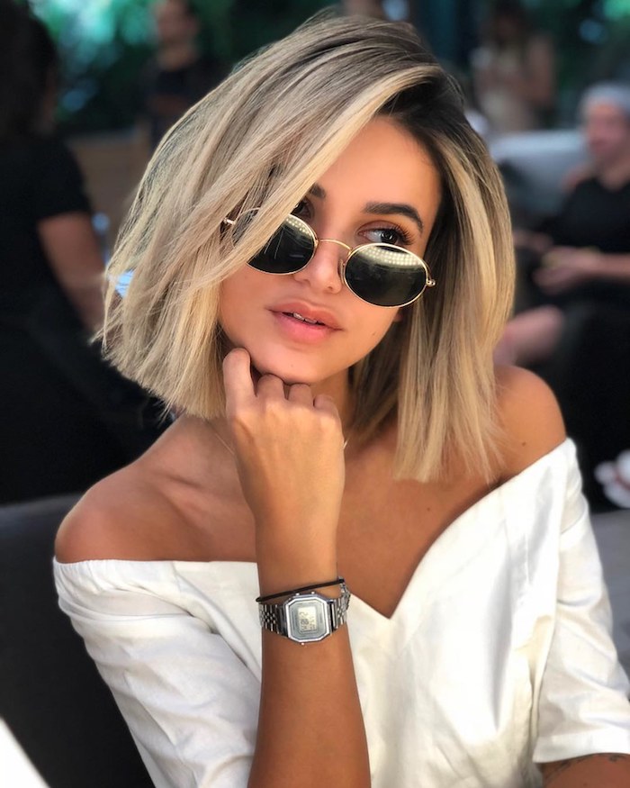 braune haare mit blonden strähnen bob frisuren mittellang runde sonnenbrillen weißes elegantes kleis modernes outfit