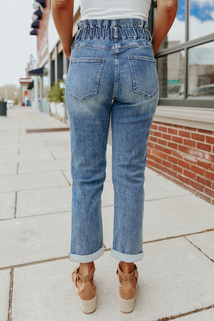 dunkle waschung jeans mit hohem bund paperbag hose stylen mit braunen schuhen mit absatz und weißem top styling inspiration