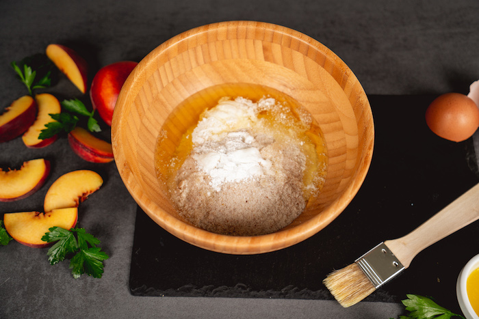 eine schüssel aus holz mit mehl und öl geschnittene pfirschiche und petersilie naan selber machen