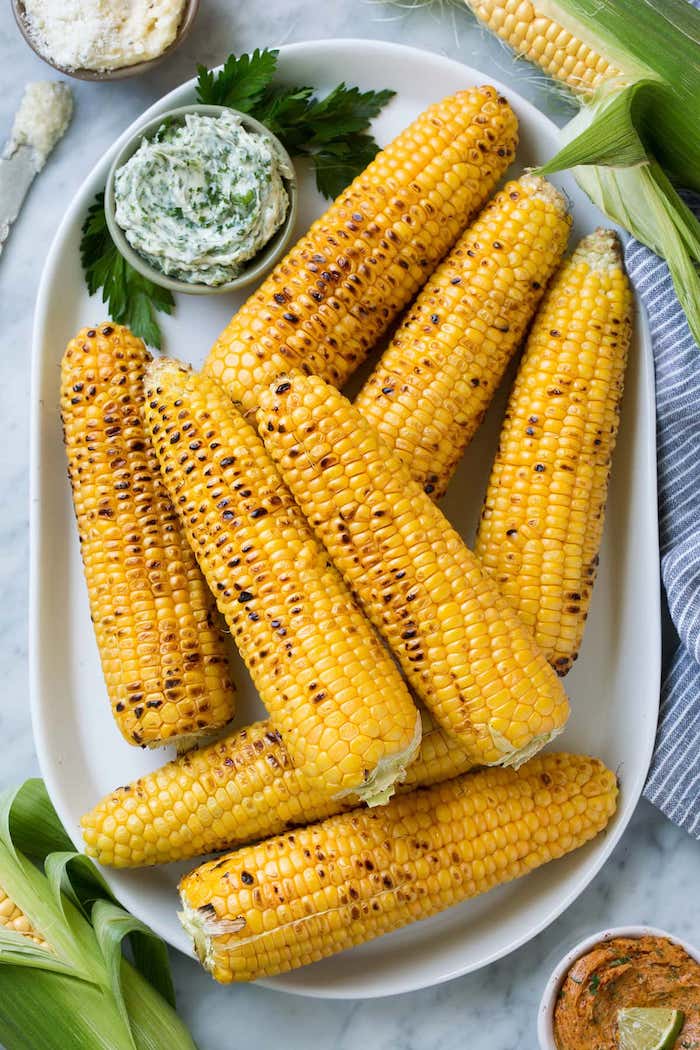 eine schüssel mit butter aus bärlauch gekochte maiskolben mit käse petersilie gewürzen und scharfen roten paprikas mexikanische gerichte