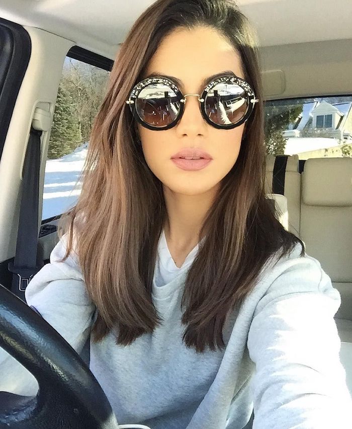 elegante runde sonnenbrillen mädchen macht selfie im auto braune mittellange haare glatt gestylt