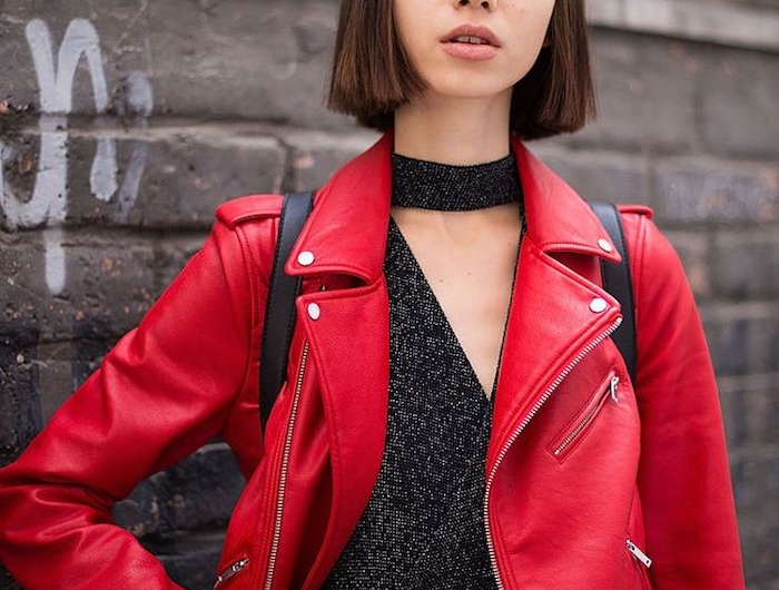 elegantes street style outfit schwarze glitzernde blude und jeans rote lederjacke bob dünnes haar mit pony kurze haarschnitte inspiration