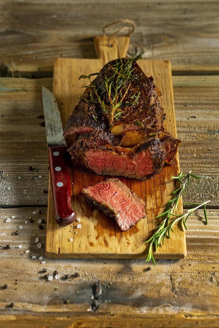 entrecote steak braten ribeye steak zubereiten rezept für rib eye steak mit knoblauchsoße gebratenes ribeye steak auf schneidebrett