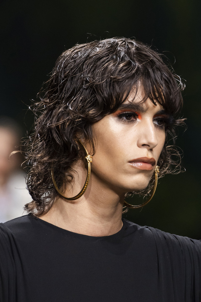 fashion week show model mit kurzen braunen haaren vokuhila frisur mit locken