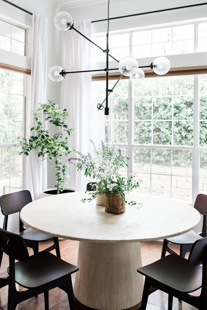 grüne pflanzen dekoration wohn esszimmer schwarze moderne stühle massiver runder tisch aus holz interior design inspiration
