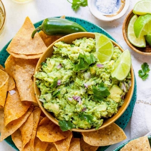 grüner teller mit nachos guacamole selber machen mit frischen avocados limetten und frischer petersilie