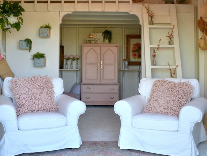 kleines gartenhaus als raum einrichten zwei weiße sofas mit flauschigen kissen pinker schrank