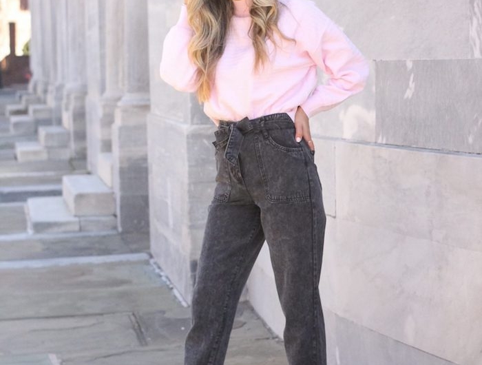 paperbag hose schwarz jeans kombiniert mit pinkem pullover clogs holzschuhe mit absatz damen mit langen gewellten haaren schwarze haare mit blonden highlights