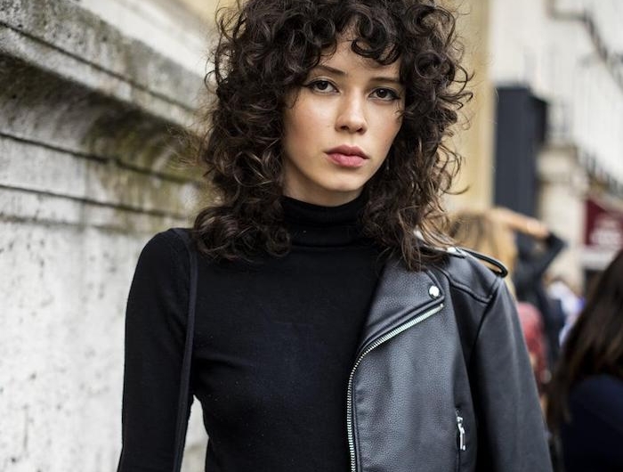 paris fashion week street style casual outfit schwarze lederjacke und rollkragenpulli shaggy frisur mittellang mit natürlichen locken dunkle haare