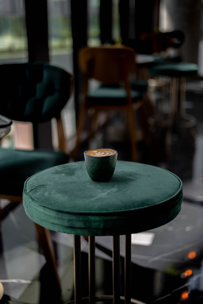runder hocker polsterhocker rund malaichit grüne polsterung kaffee tasse habitat design metal beine cafe