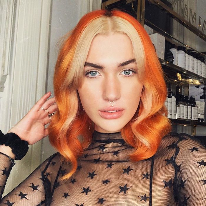 schwarze durchsichtige bluse mit sternen orange haare blonde strähne vorne ausgefallene haarfarben inspiration trendige frisuren mittellange haare gewellt