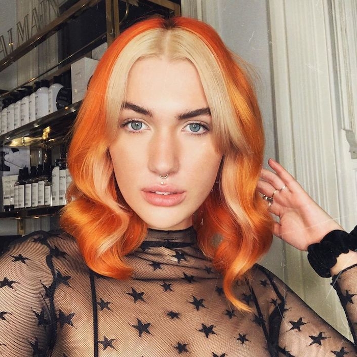 schwarze durchsichtige bluse mit sternen orange haare blonde strähne vorne ausgefallene haarfarben inspiration trendige frisuren mittellange haare gewellt