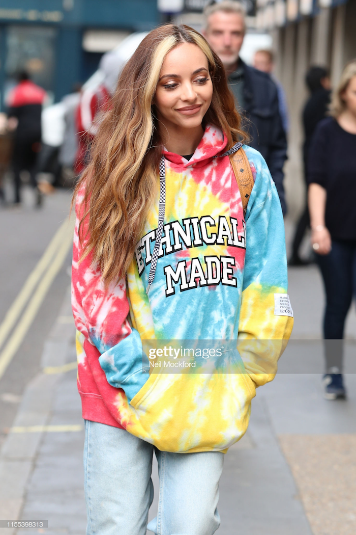 street style look oversized sweatshirt batiken bunt mit jeans frau mit langen dunkel blonden haaren blonde strähnen vorne haarfarbe 2021 inspiration