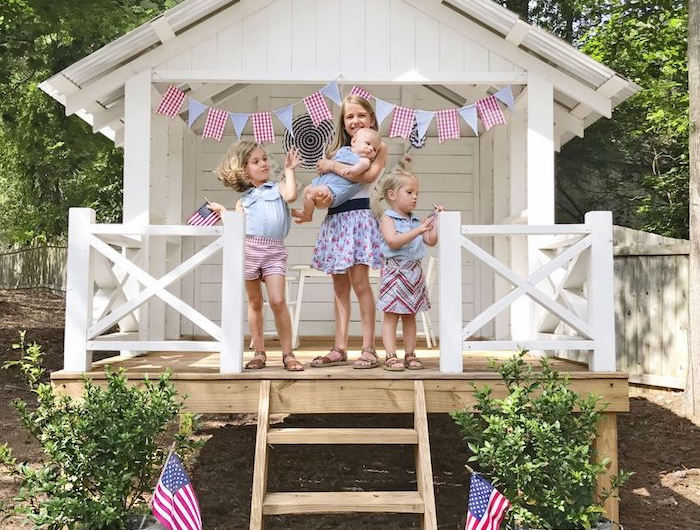 vier kleine kinder gartenhäuser aus holz modern einrichten für kinder weißes haus deko fahnen in blau und rot