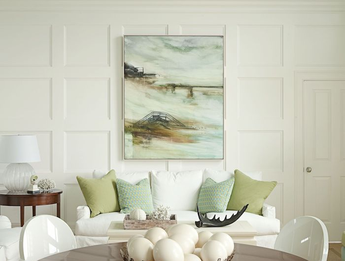 wandfarbe weiß grün wohnzimmer mit essbereich runder tisch aus holz weiße stühle weißes sofa mit grünen und weißen kissen moderne inneneinrichtung