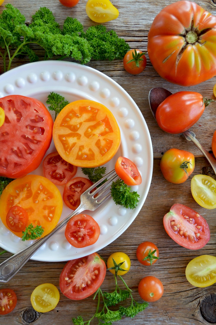 weißer teller mit geschnittenen roten tomaten ein tisch aus holz rote tomaten salat zum grillen schnell gemacht