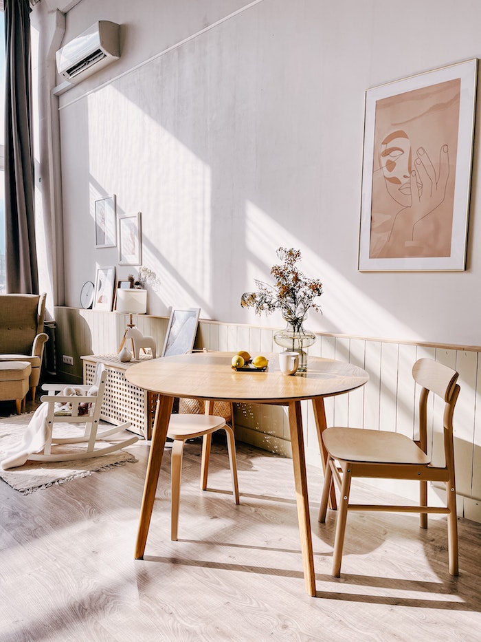 wohnung einrichten wohnzimmer mit essbereich gestalten kleiner runder tisch und stühle aus holz minimalistische wandgestaltung modernes gemälde