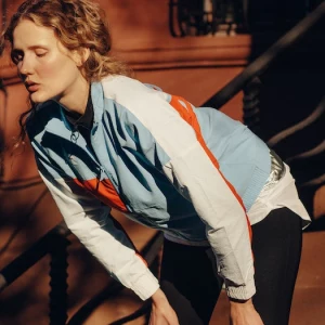 blonde frau macht pause nach dem jogging bunte sport jacke schwarze leggins was hilft gegen muskelkater tipps und info