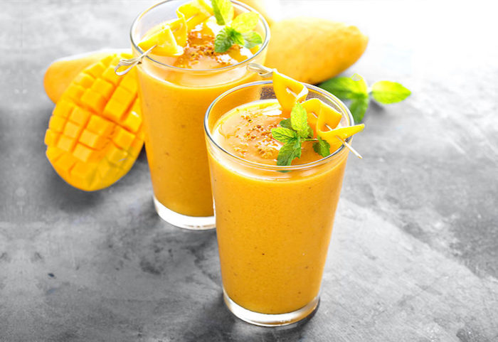 mango milchshake selber machen rezept mango smoothie selber machen frische mangos exotischer honig zwei gläser mit mango milchshake und frischen nasilikumblätter