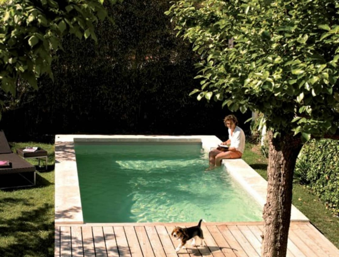 mann sitz mit füßen im schwimmbad kleiner hund pool für kleinen garten grüne bäume und pflanzen
