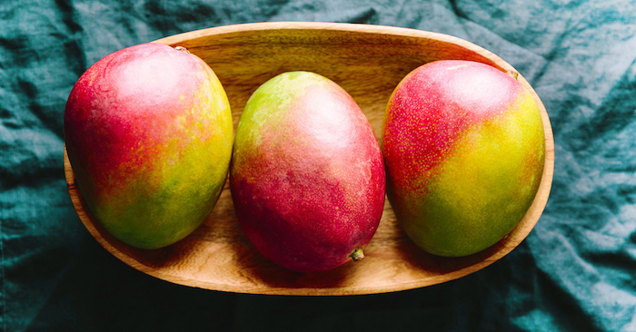 shake mango banana rezept für milchshake selber machen mit mango und früchten drei grün rote mangos in holzschüsel auf blauem tuch