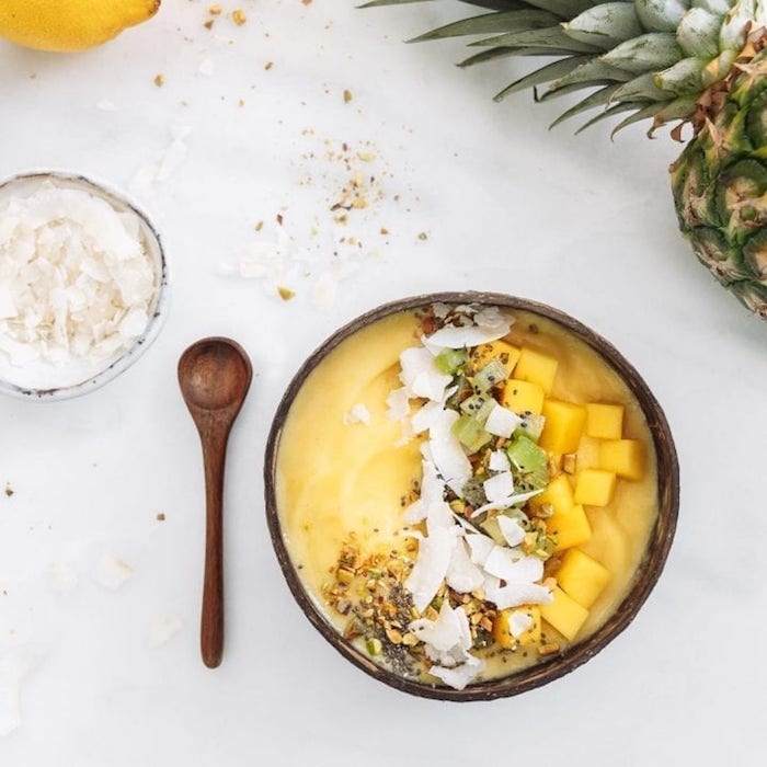 smoothie mit mango mango milchshake selber machen aus kokosmilch holz bowl mit mango nüssen kokos holz löffel