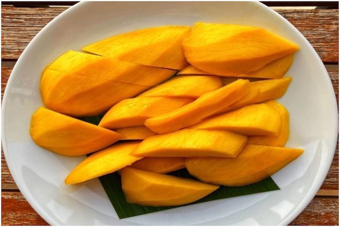 smoothie mit mango mango smoothie frozen mango smoothies frissche mango in streifen schnieden auf weißem teller