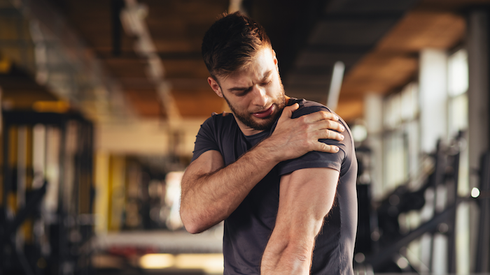 sport treiben mann im grauen t shirt hausmittel gegen beinschmerzen muskelkater bekämpfen schmerzfrei trainieren