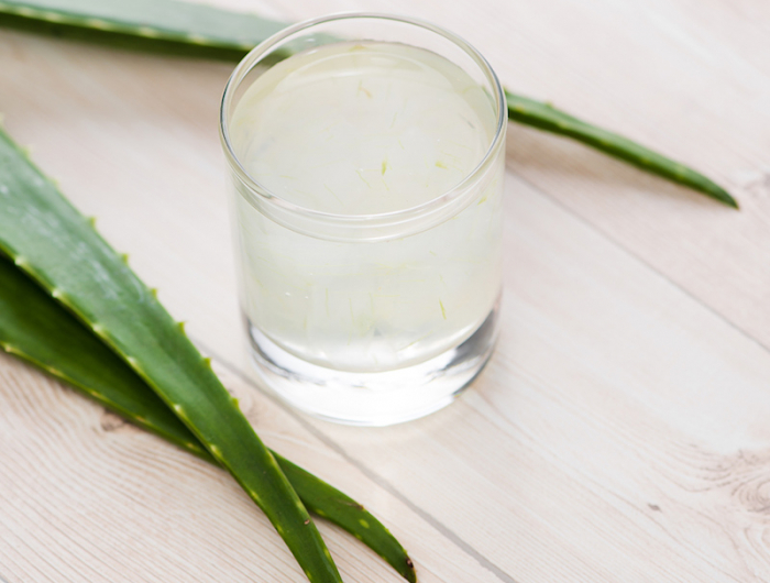 glass of aloe vera juice with fresh leaves