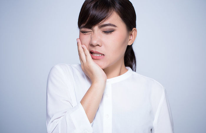 zahnschmerzen was tun zahnschmerzen lindern entzündungshemmende hausmittel zahnfleischschmerzen junge frau leidet an zahnschmerzen