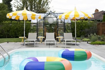 zwei große bunte rettungsringe schirme in gelb und weiß drei chaiselongues swimming pool garten inspiration und ideen