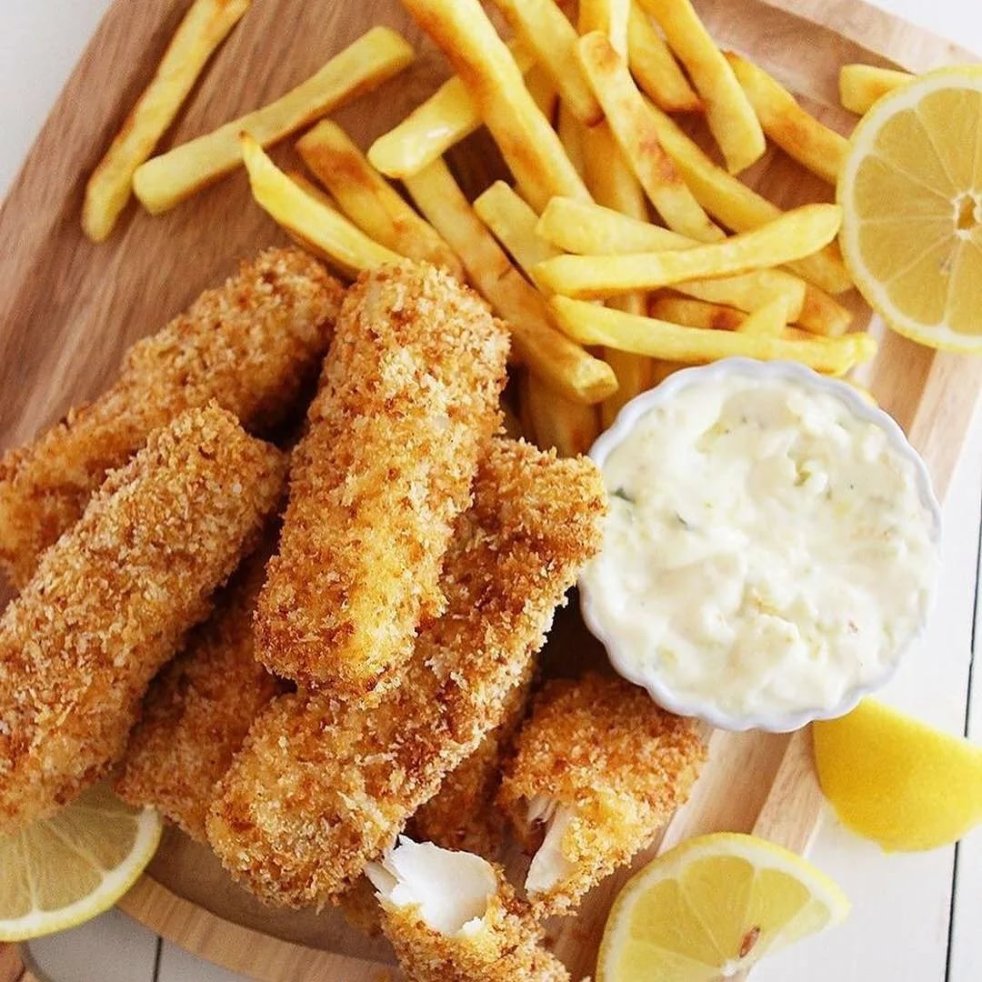 beilage fischstäbchen pommes mayonnaise und zitronen auf holzbrett