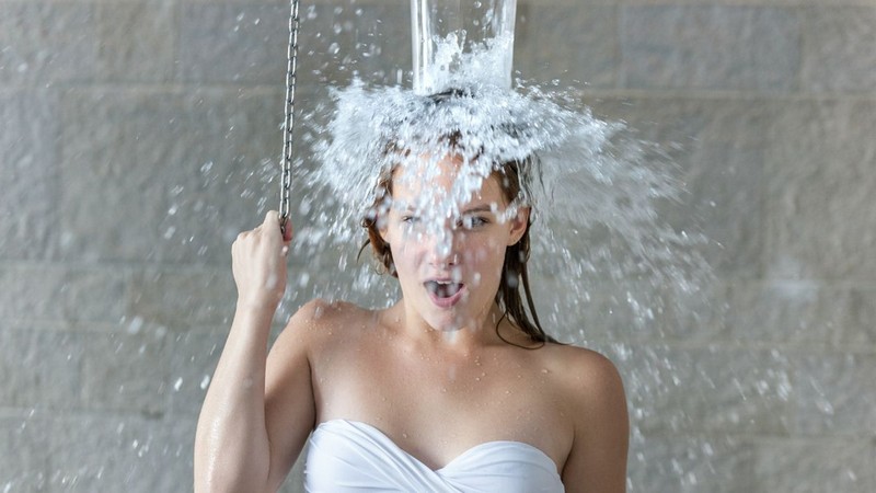 fußbad mit natron gegen geschwollene beine entwässerung körper kalte dusche gegen geschwollene beine junge frau duscht