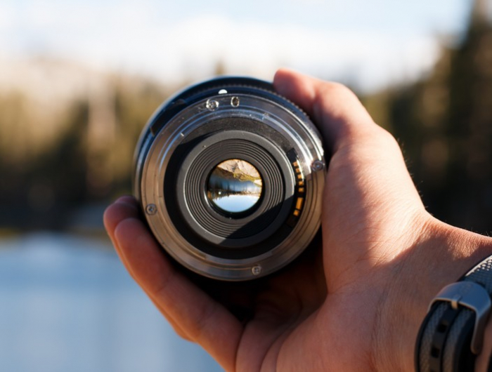 selective focus shot of a person holding a camera lens
