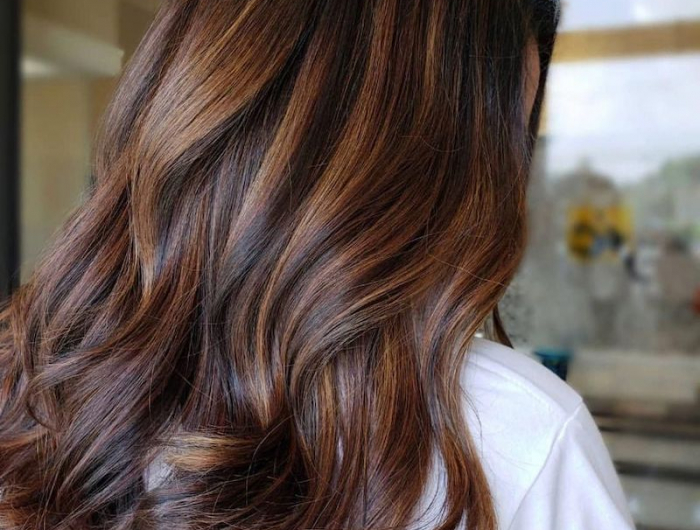 kastanienbraun haarfarbe mit karamell strähnen eine frau beim friseur